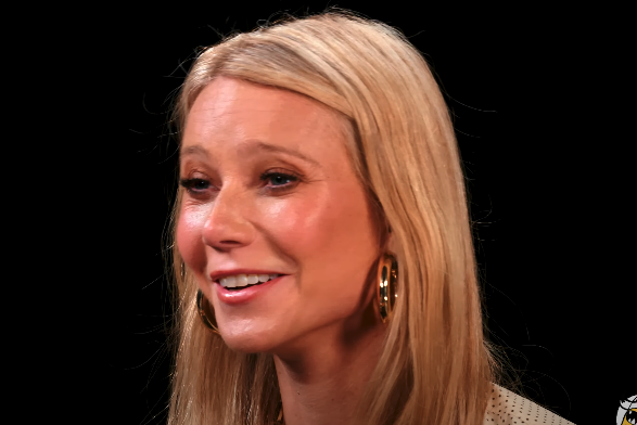 Close-up of a smiling Gwyneth, wearing hoop earrings