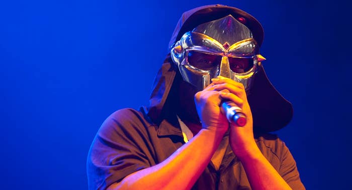 Music artist in mask singing into microphone on stage