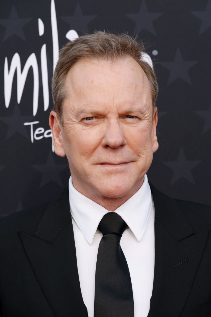 Kiefer in a black suit and tie at an event