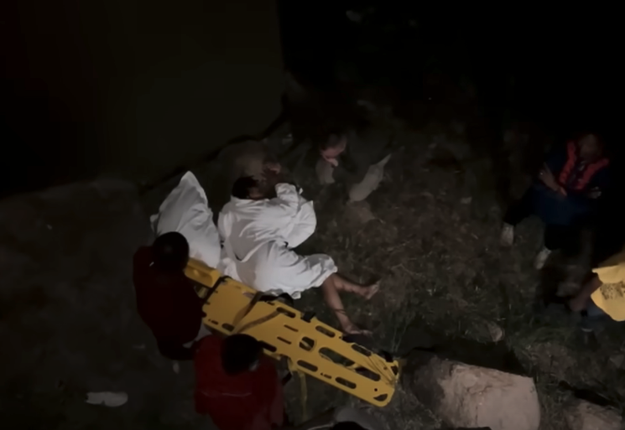 Emergency personnel attending to an injured Jenifer at night