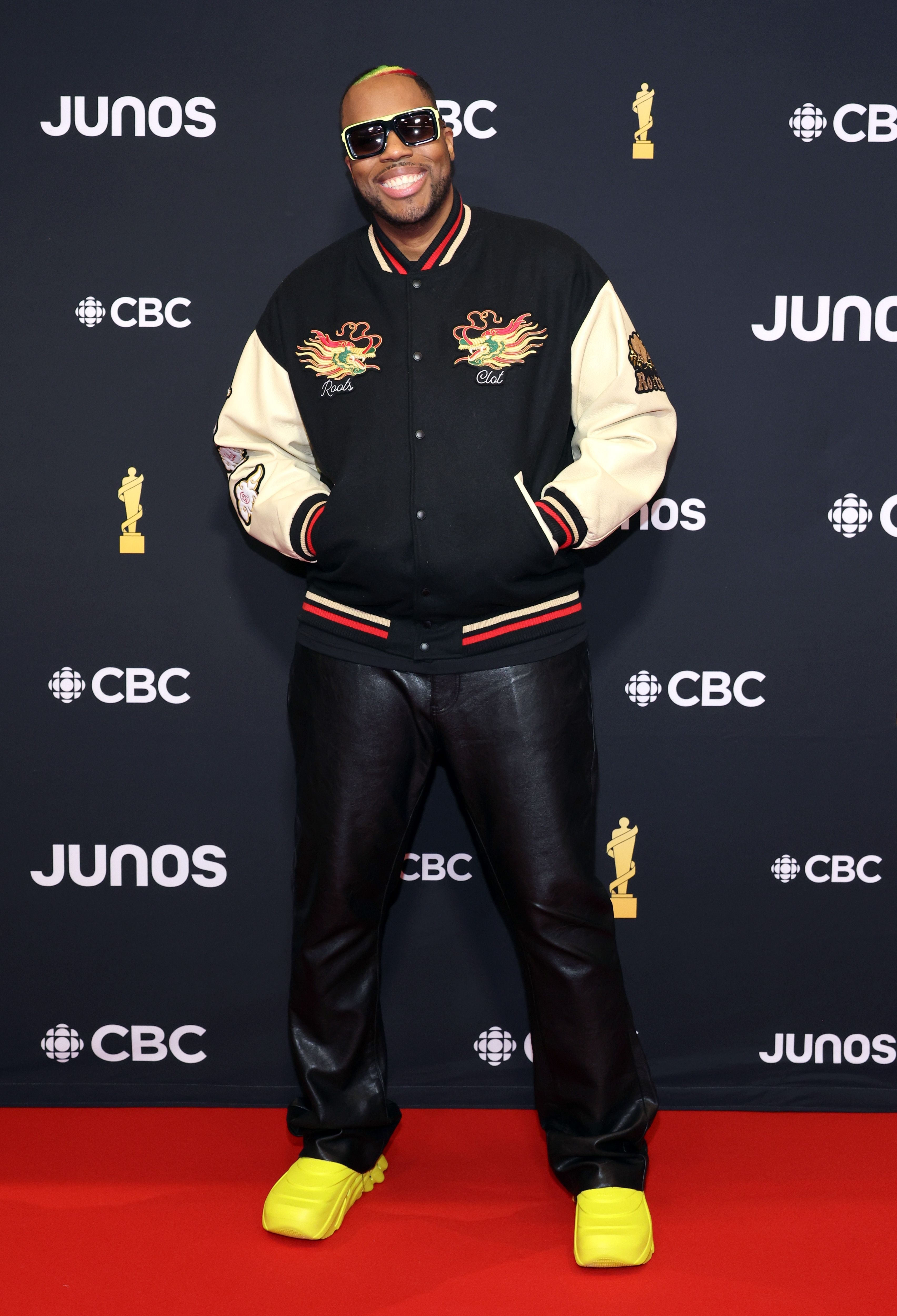 Man in a varsity jacket and bright sneakers posing at the Junos event