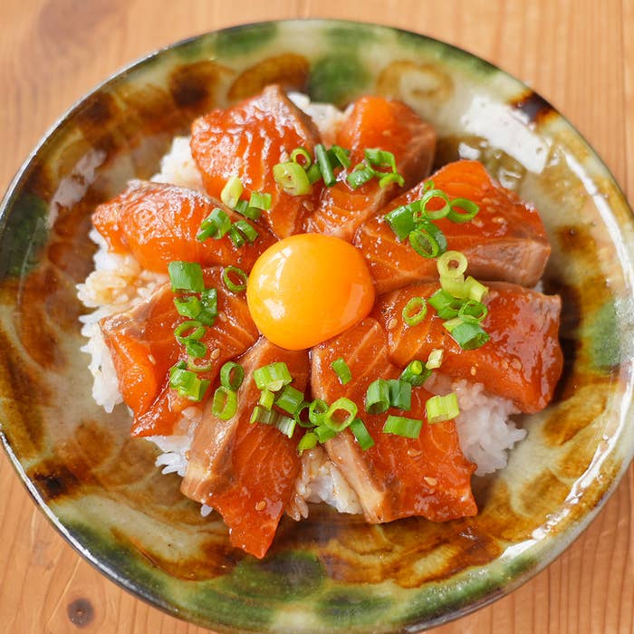 ご飯の上にサーモンと生卵黄、刻んだネギがのった丼物です。