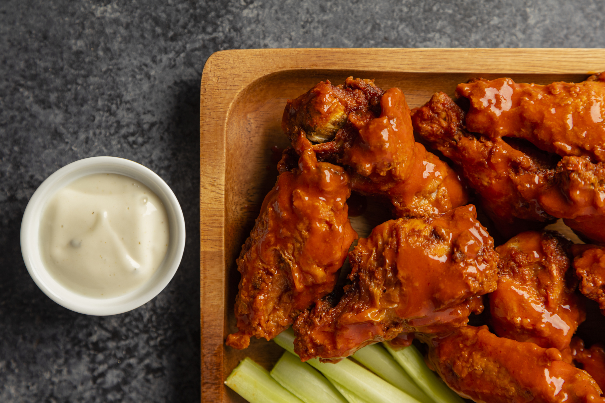 Buffalo wings on a plate with celery sticks and dipping sauce