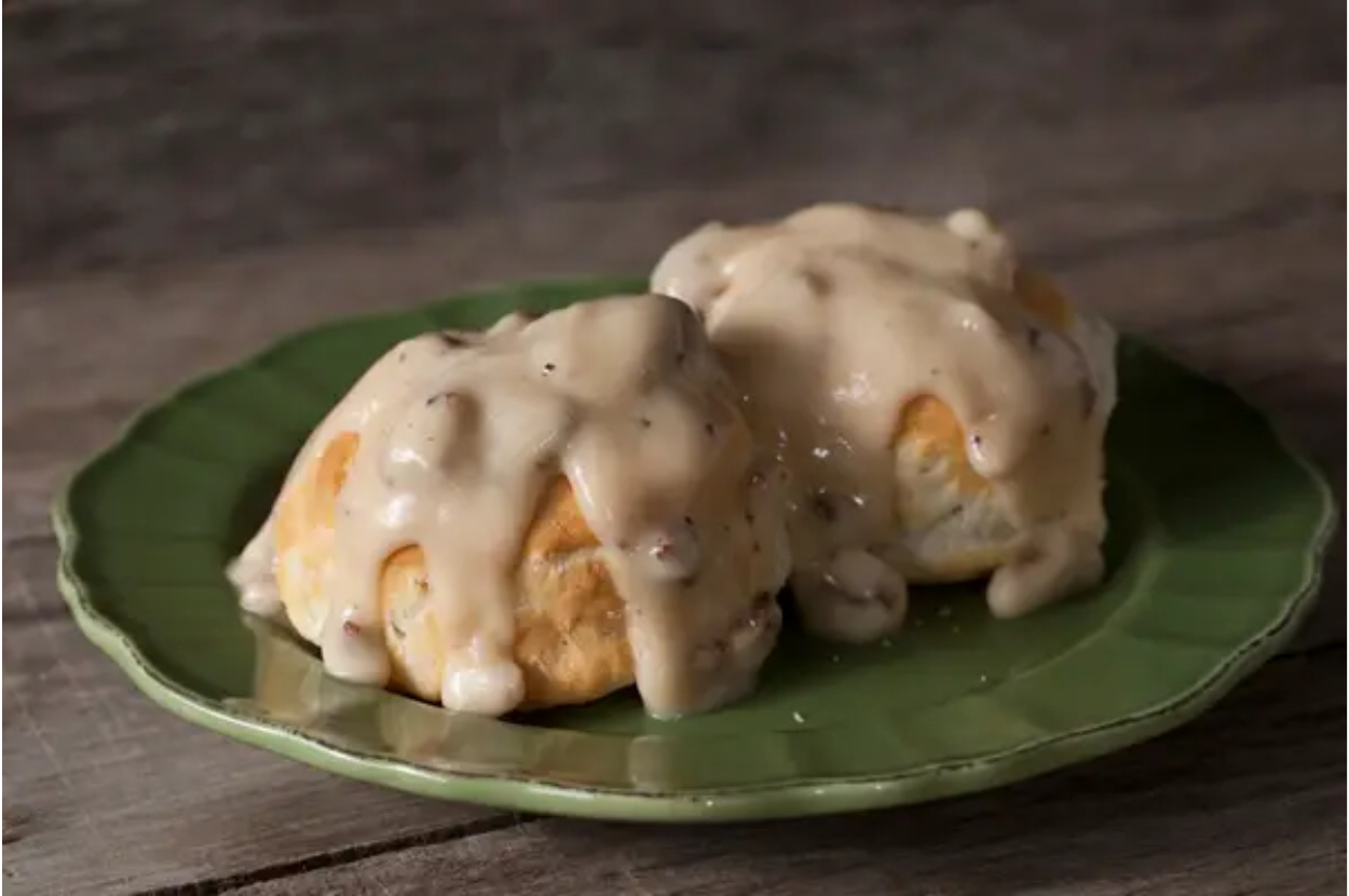 Biscuits topped with creamy gravy on a green plate