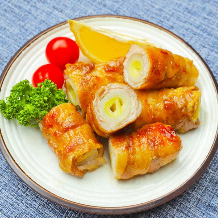 皮で巻かれたネギの肉焼き、トマトとパセリ添え。