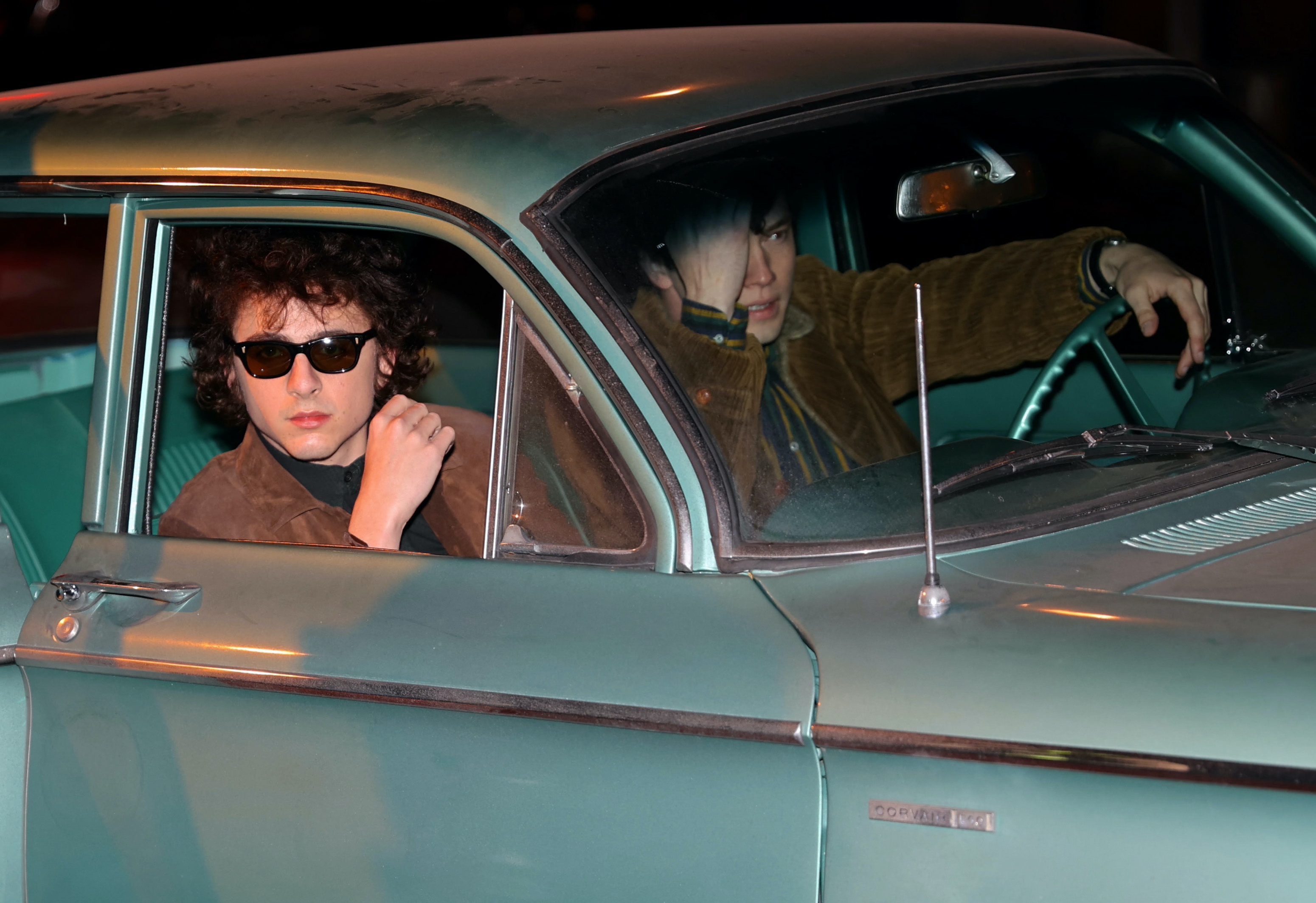 The two actors in a vintage car, Timmy wearing sunglasses, and another man in the driver&#x27;s seat