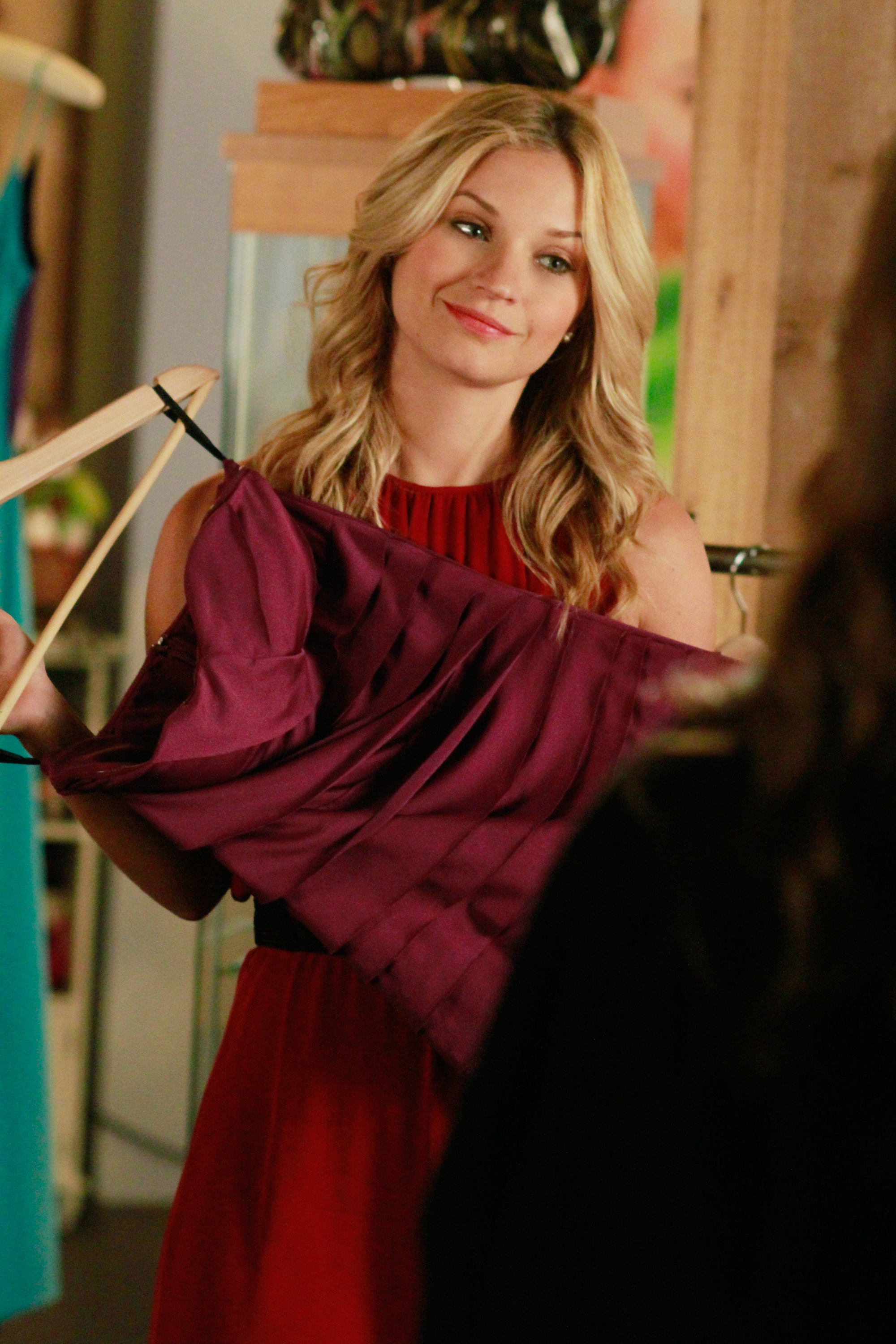 CeCe holding up a dress, smiling