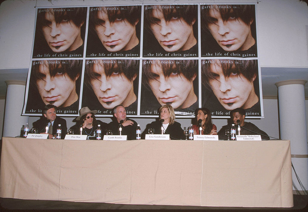 Panelists seated at a table with promotional posters for &quot;The Life of Chris Gaines&quot; in the background