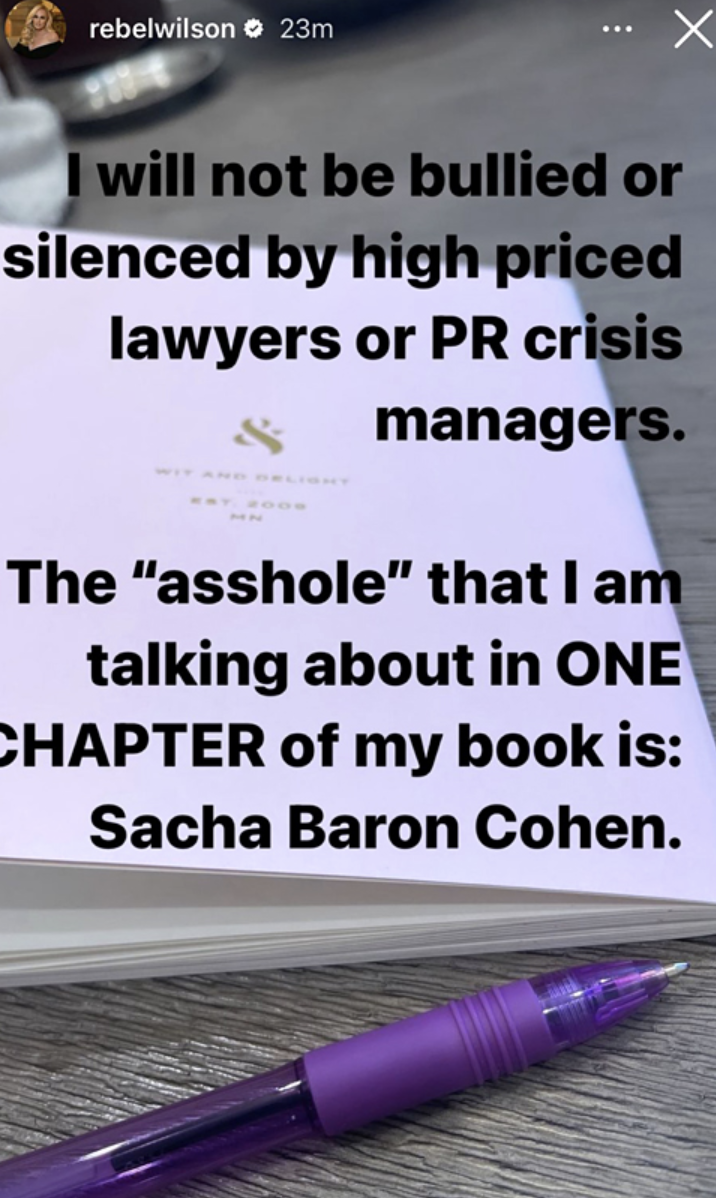 A close-up of a book page with text, a pen, and a caption by Rebel Wilson mentioning Sasha Baron Cohen