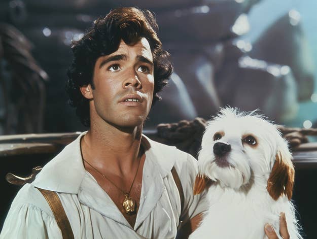 Actor in pirate costume with a small dog beside him, expressing concern