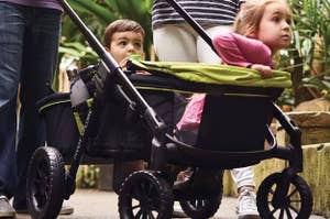 Two children in a stroller designed for shopping ease, with ample space beneath for items