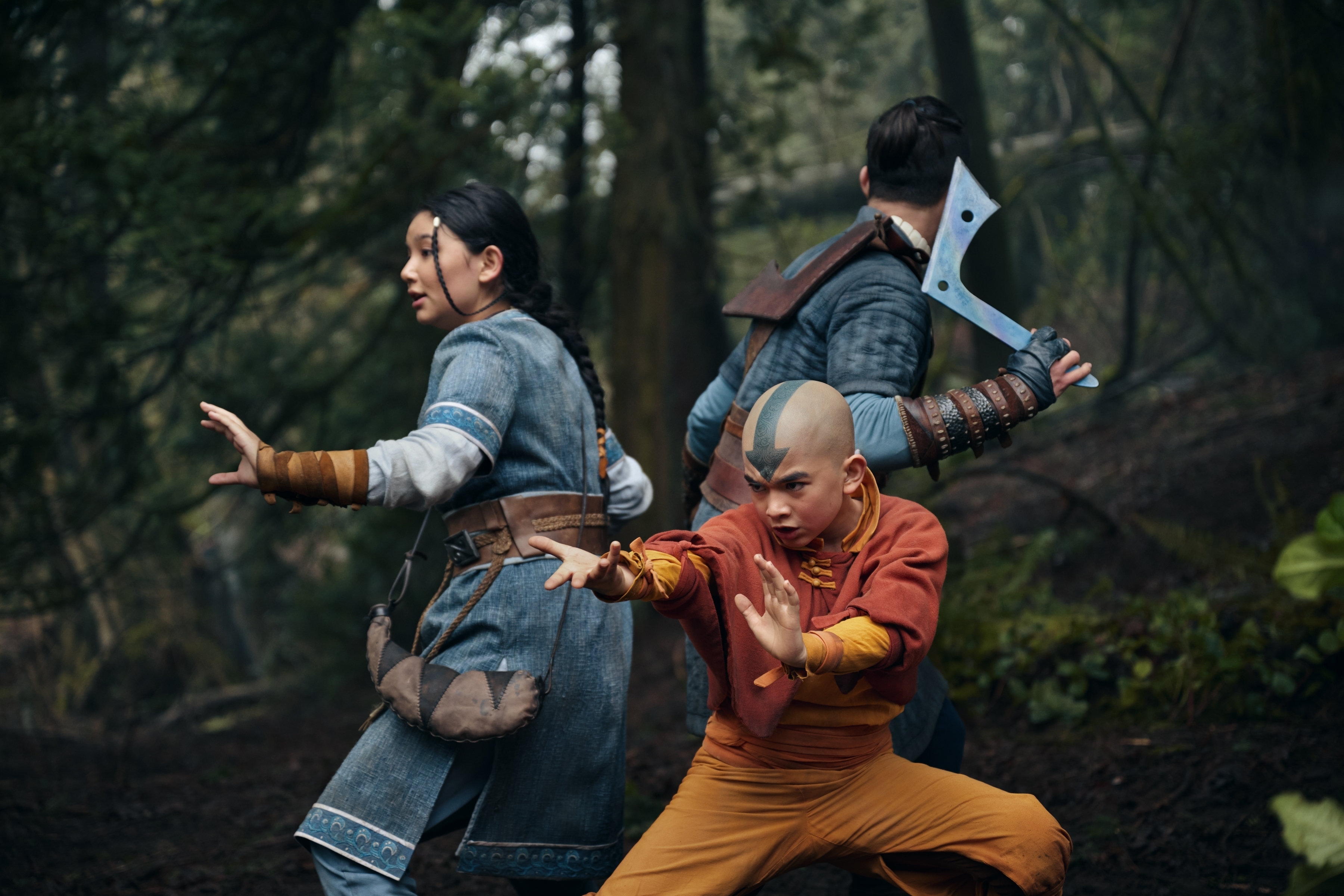 Katara, Aang, and Sokka from &quot;Avatar: The Last Airbender&quot; in a live-action pose, wearing character-specific outfits