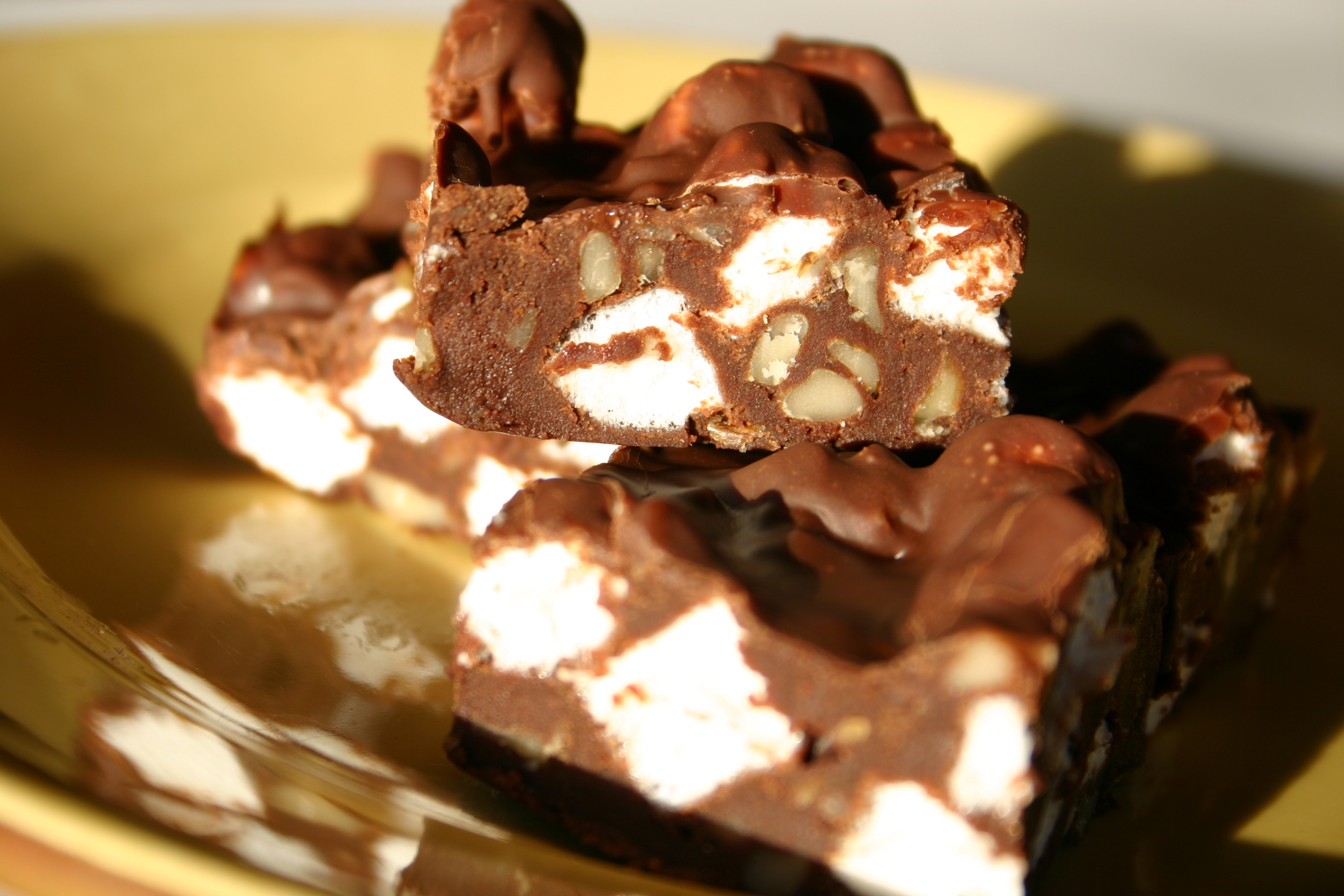 Close-up of a rocky road chocolate bar with marshmallows and nuts on a plate