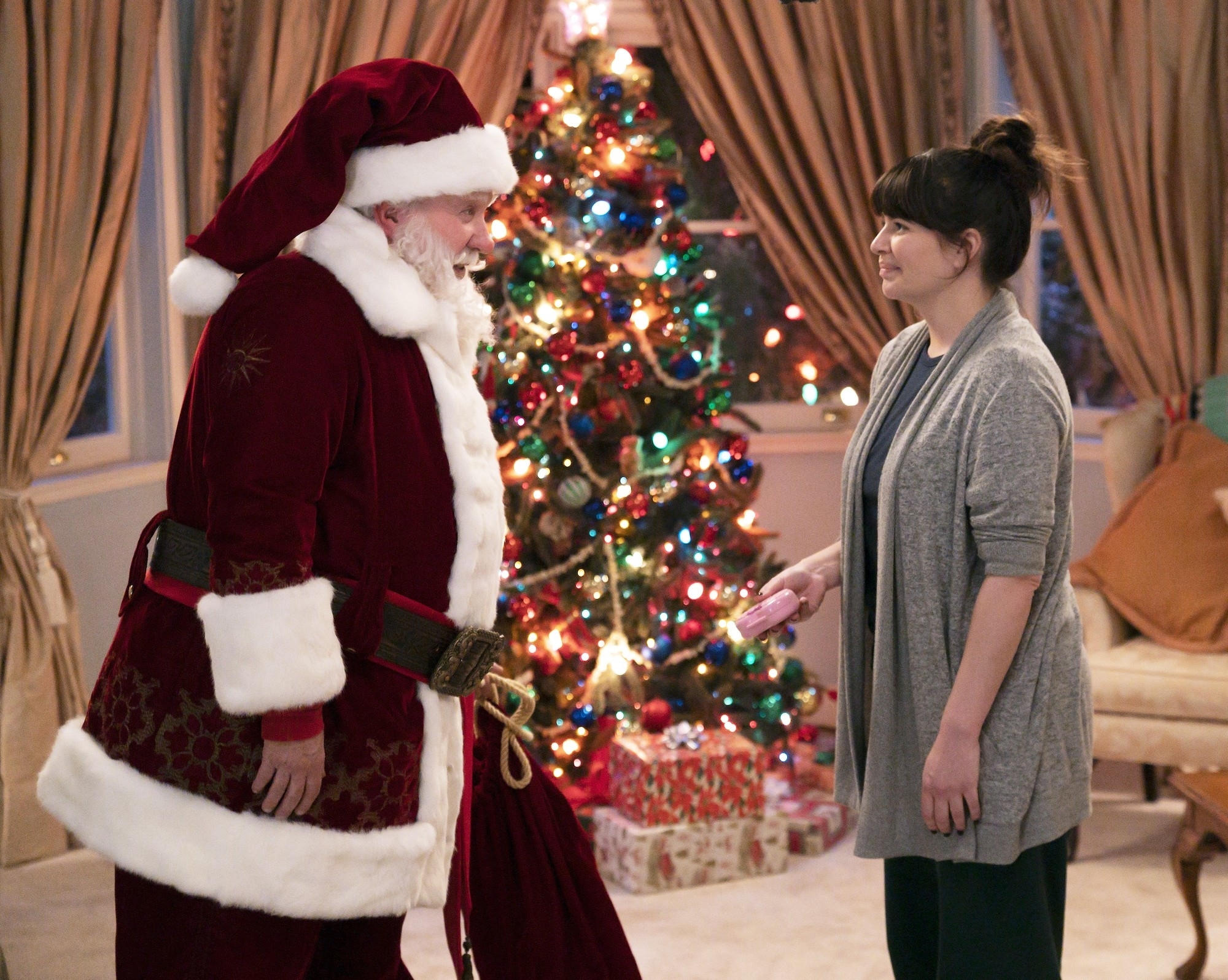 Tim and Casey on set, him in a Santa suit and her dressed casually