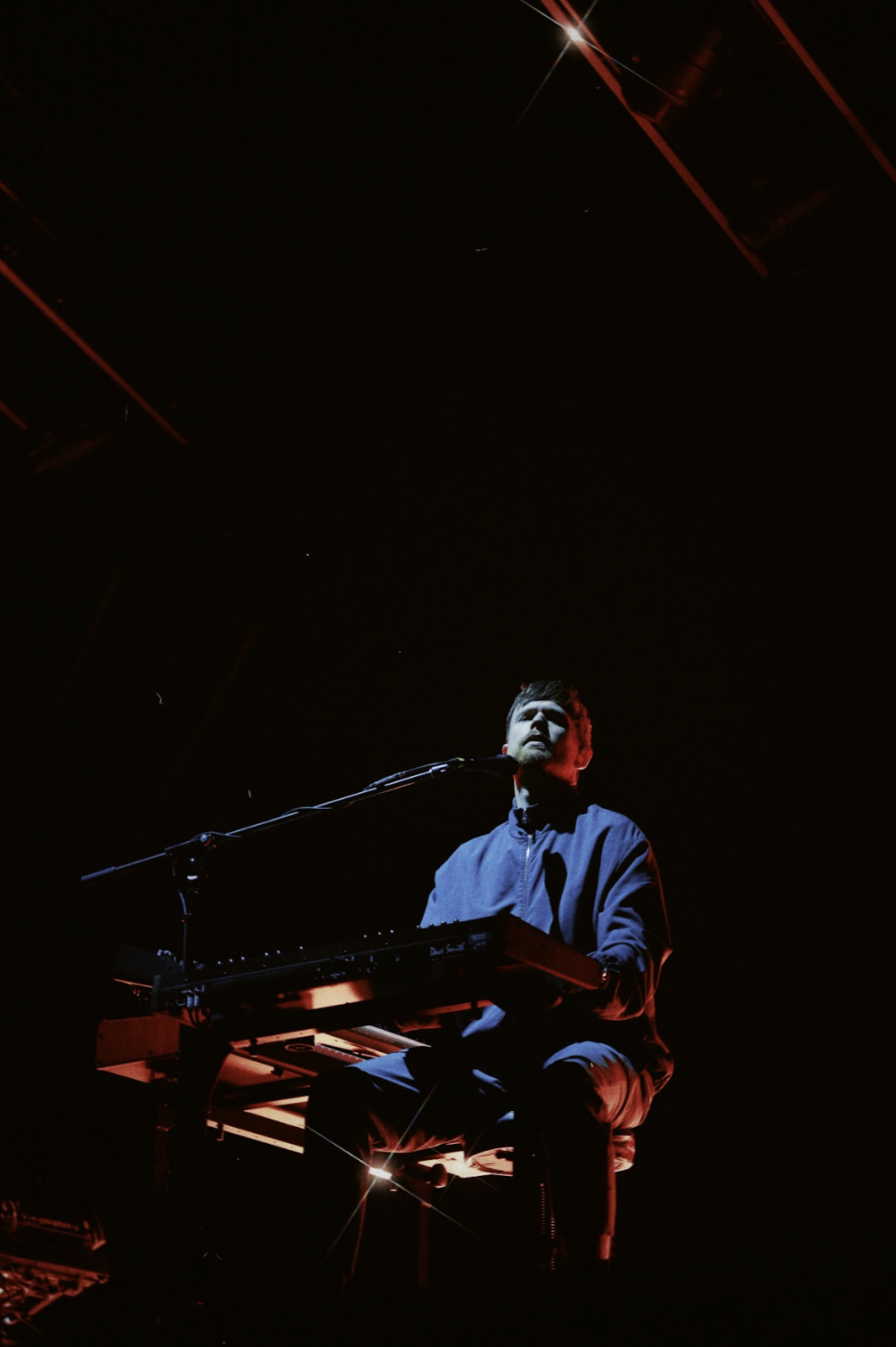 Músico en concierto tocando el piano bajo reflectores