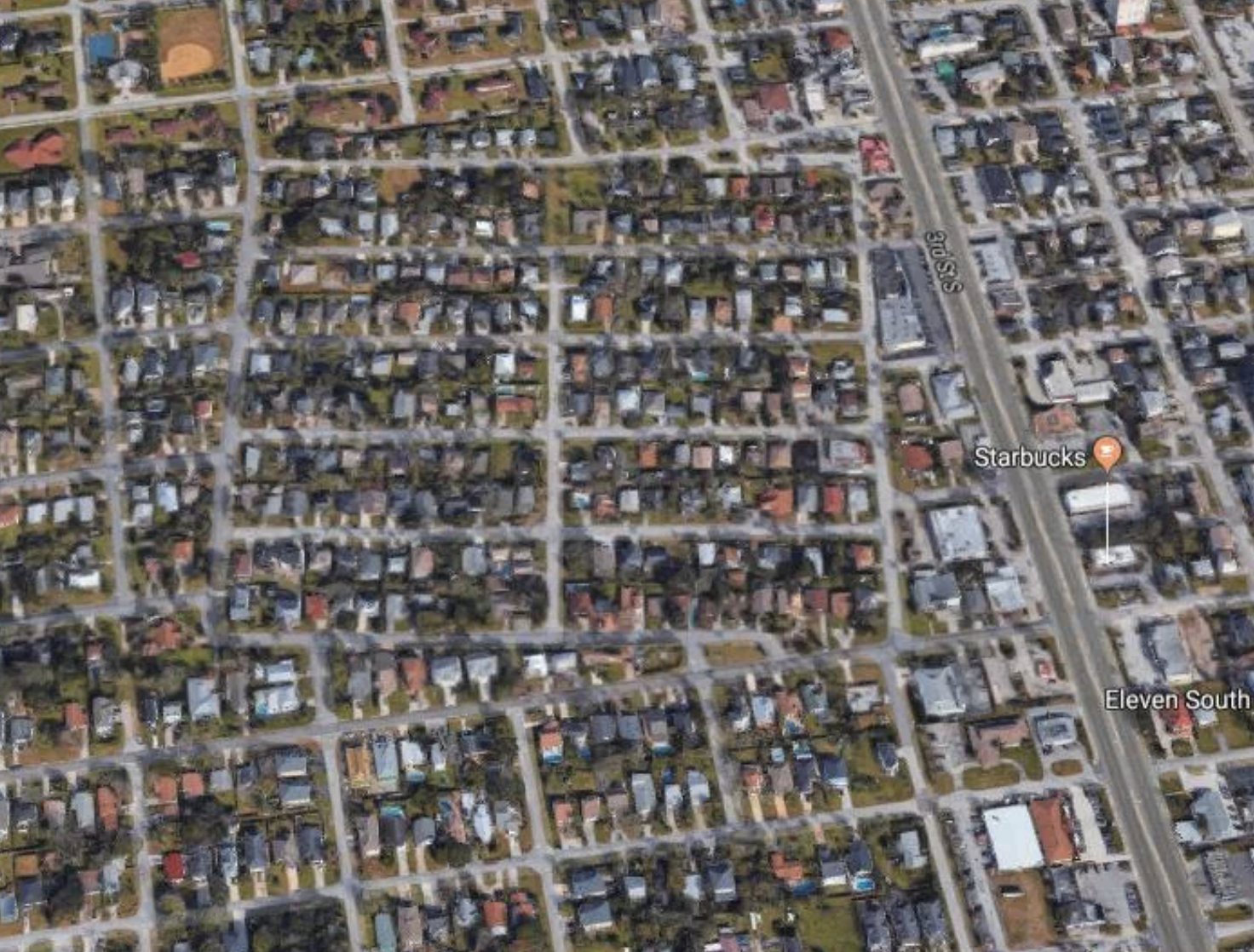 Aerial view of a dense residential area with a squared off community that is crooked on the map