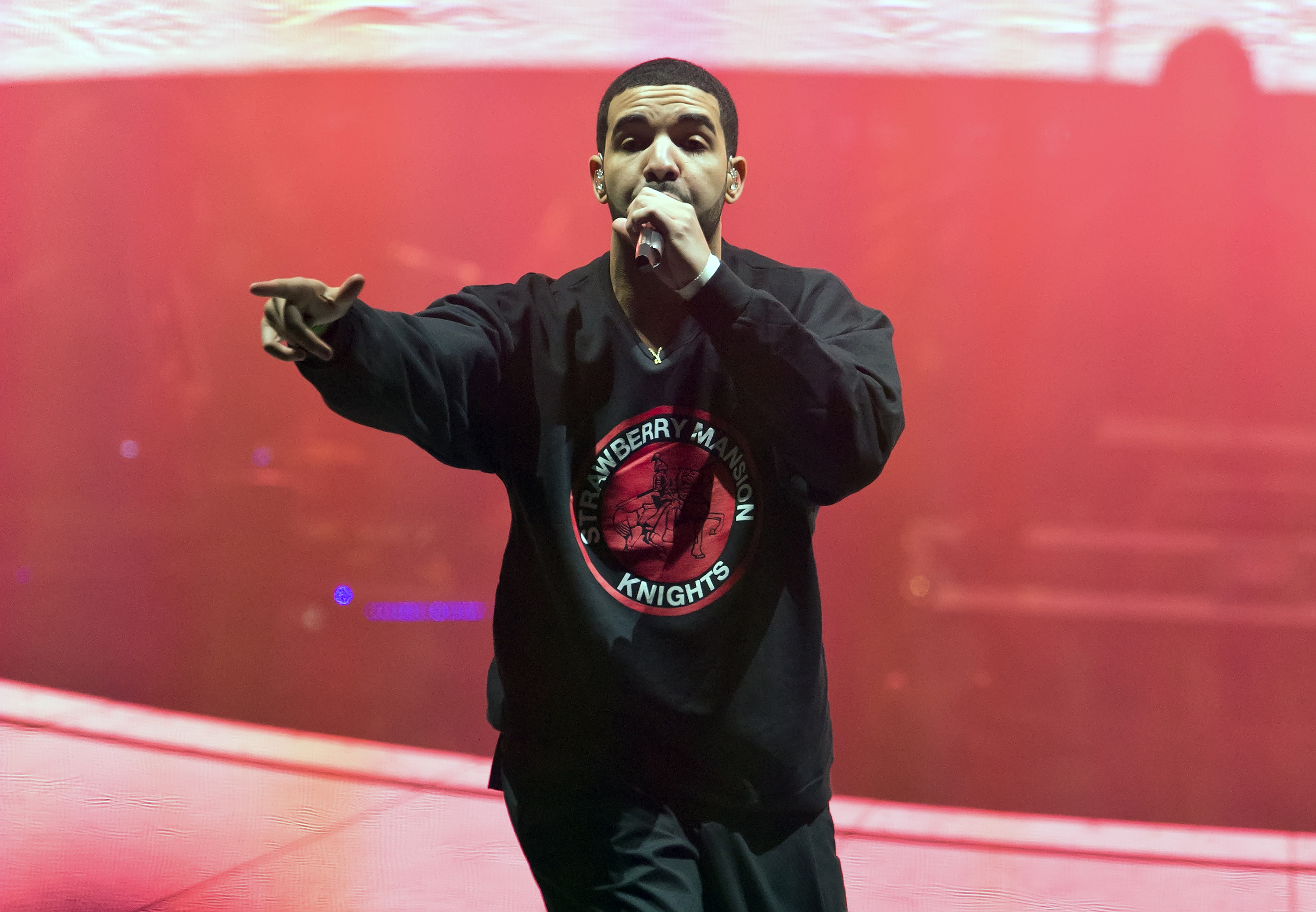 Drake performing on stage wearing a graphic t-shirt