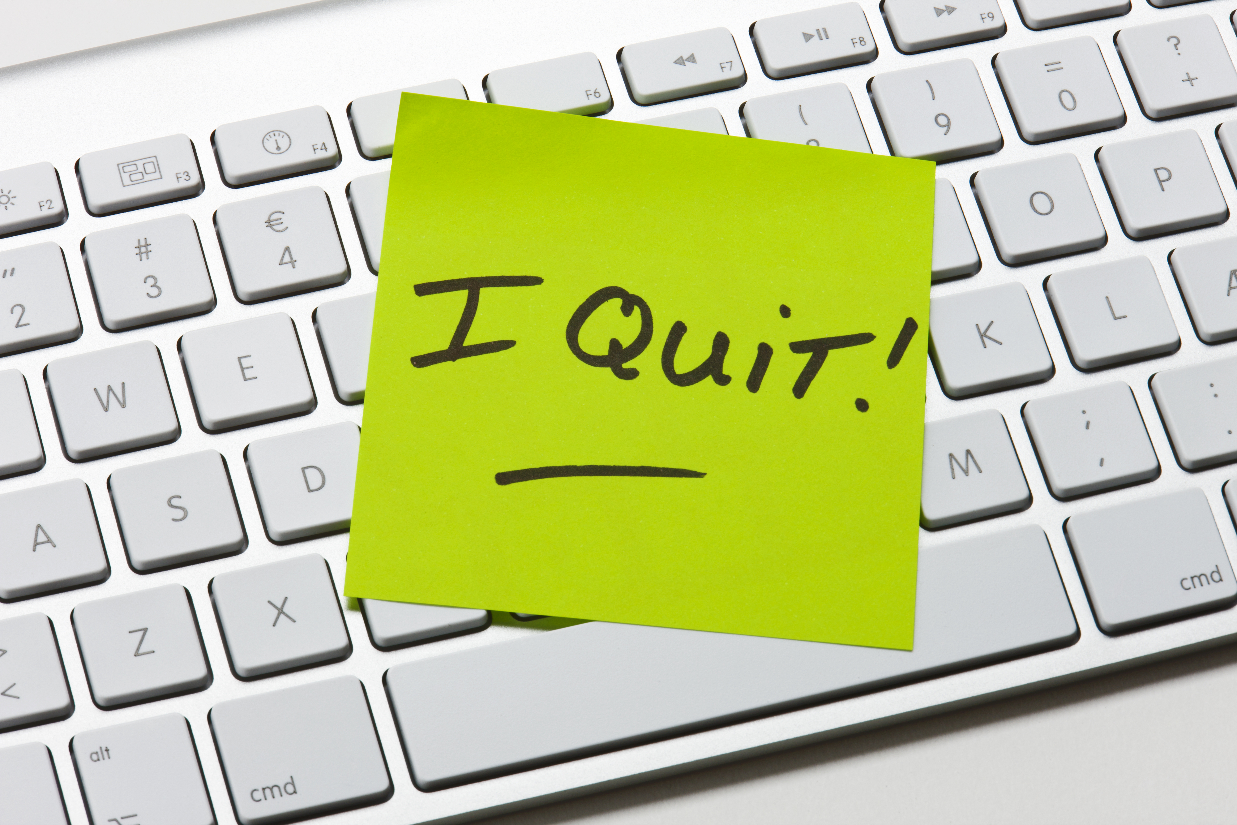 Post-it note with &quot;I Quit!&quot; handwritten, placed on a computer keyboard, indicating resignation