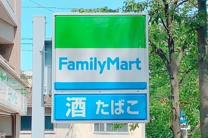 ファミリーマートの看板があり、周囲には木々と建物が見えます。