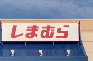 Signboard with Japanese characters on a building's facade under a clear sky