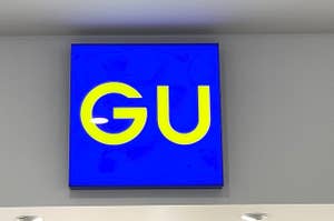 Sign with the letters "GU" mounted on a wall