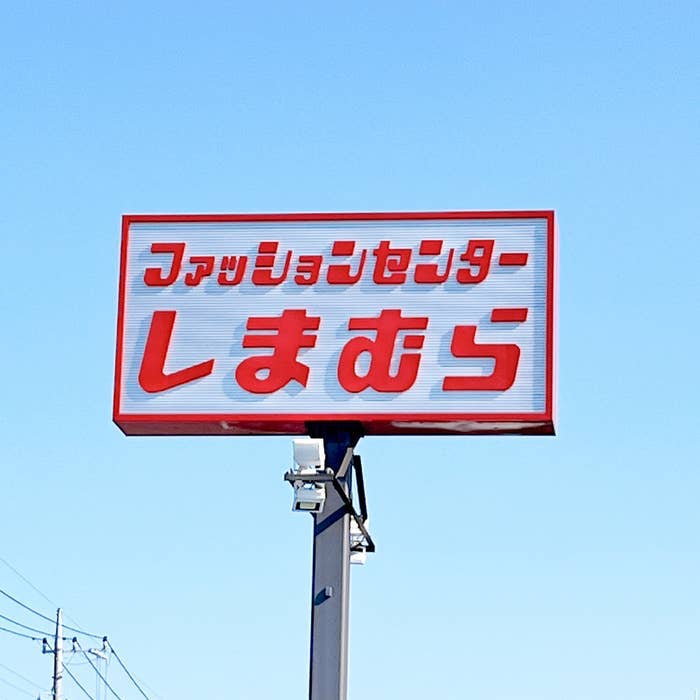 Sign with Japanese text against a clear sky on a pole