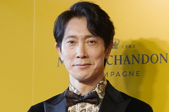 イベントに出席する男性、ベルベットのジャケットにパターン入りシャツと蝶ネクタイ。