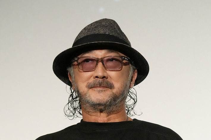 帽子をかぶり、メガネをかけた男性が「STAR WARS THE CLONE WARS」のTシャツを着て立っている。