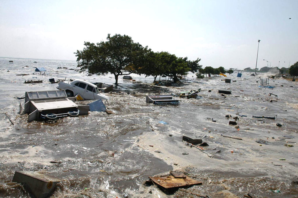 Flooded area with submerged vehicles and debris, indicating a natural disaster scene