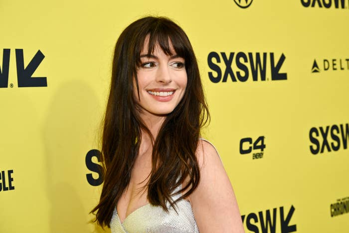 Woman in a glittery top smiling at an event with SXSW logos in the background