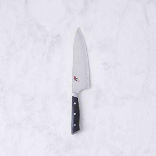 Chef&#x27;s knife with triple-riveted black handle on a white background, essential for culinary tasks