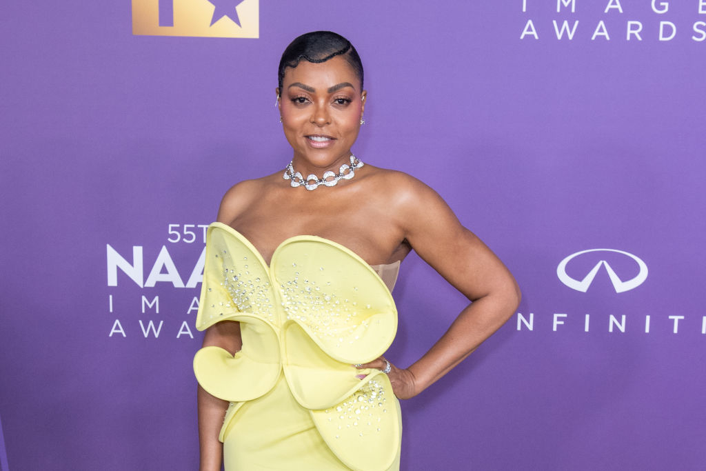 Taraji in a unique dress with a large ruffled detail, posing on the NAACP Image Awards backdrop
