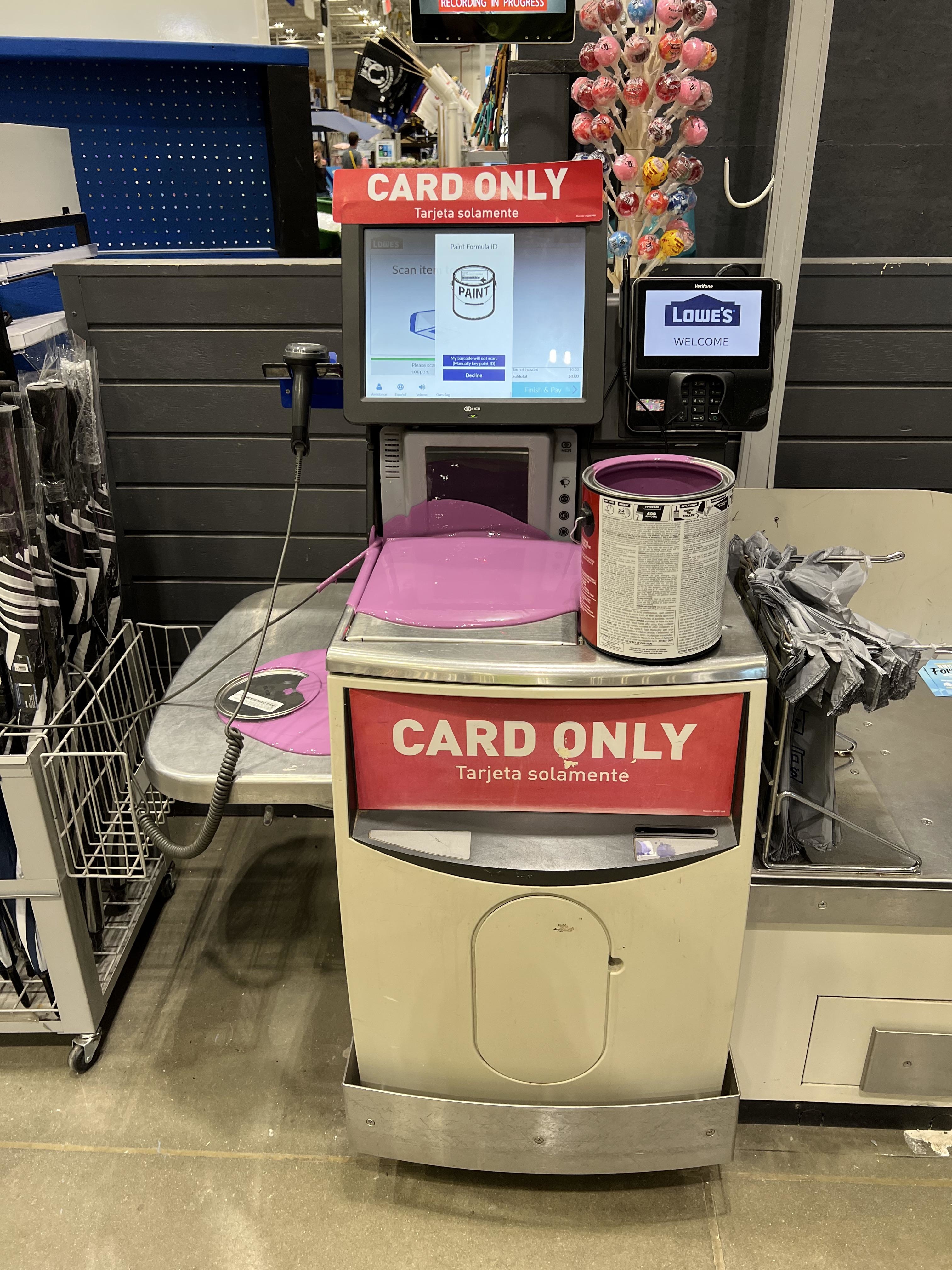 Self-checkout kiosk with &quot;CARD ONLY&quot; sign, screen prompts for payment, and a shopping basket with items on it