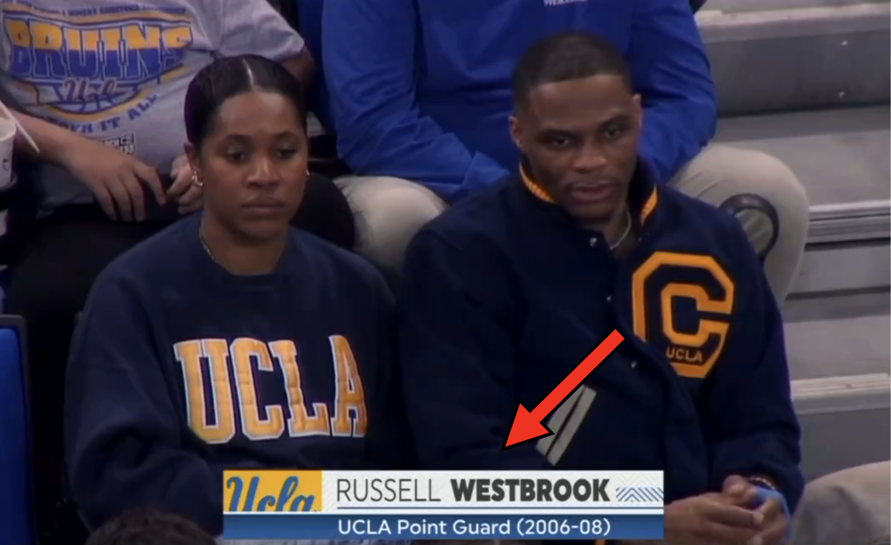 Russell Westbrook and companion sitting courtside, wearing UCLA sweatshirts. Text overlay identifies him as a former UCLA point guard