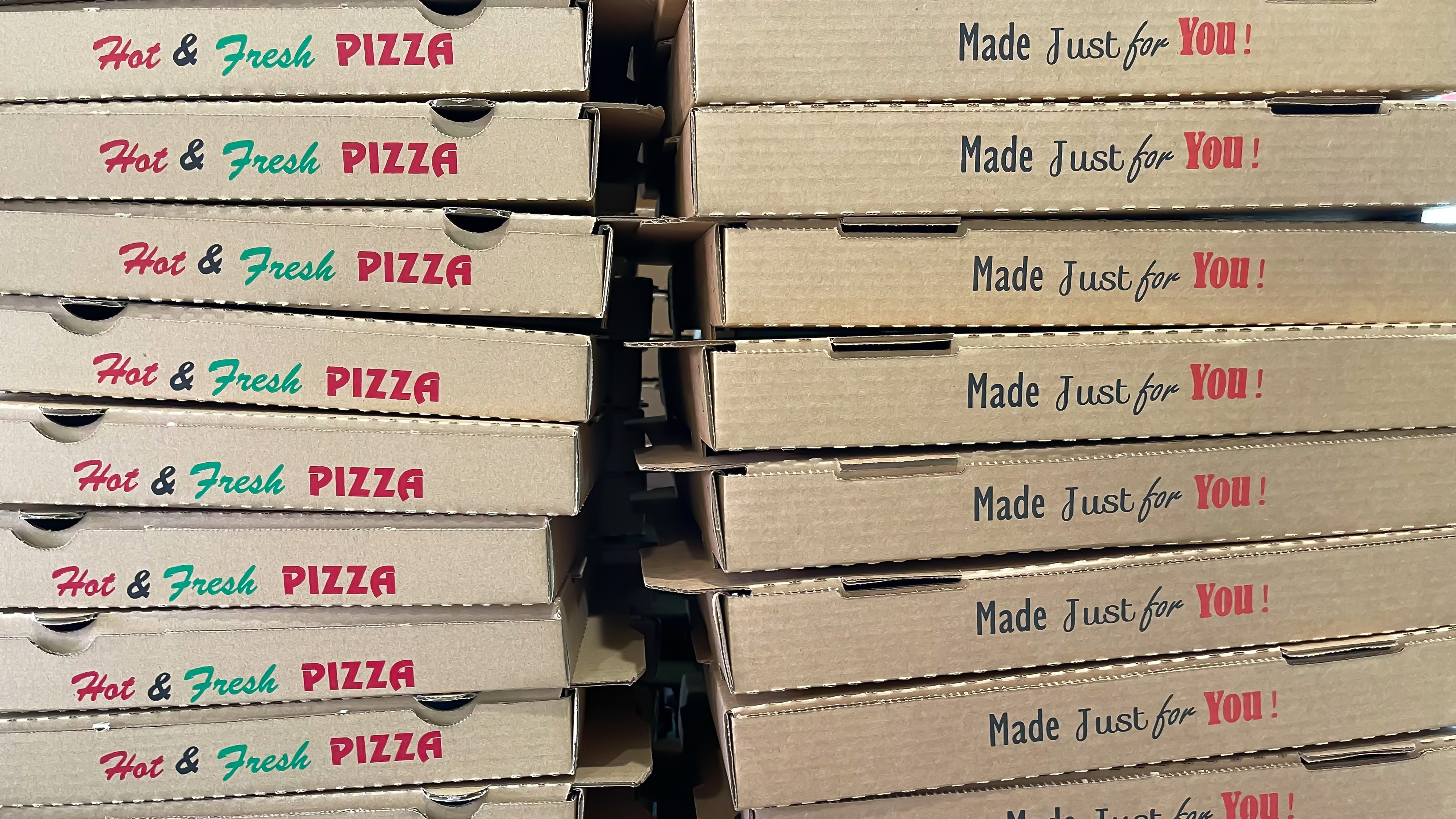 Stack of pizza boxes with &quot;Hot &amp;amp; Fresh PIZZA Made Just for You!&quot; written on them