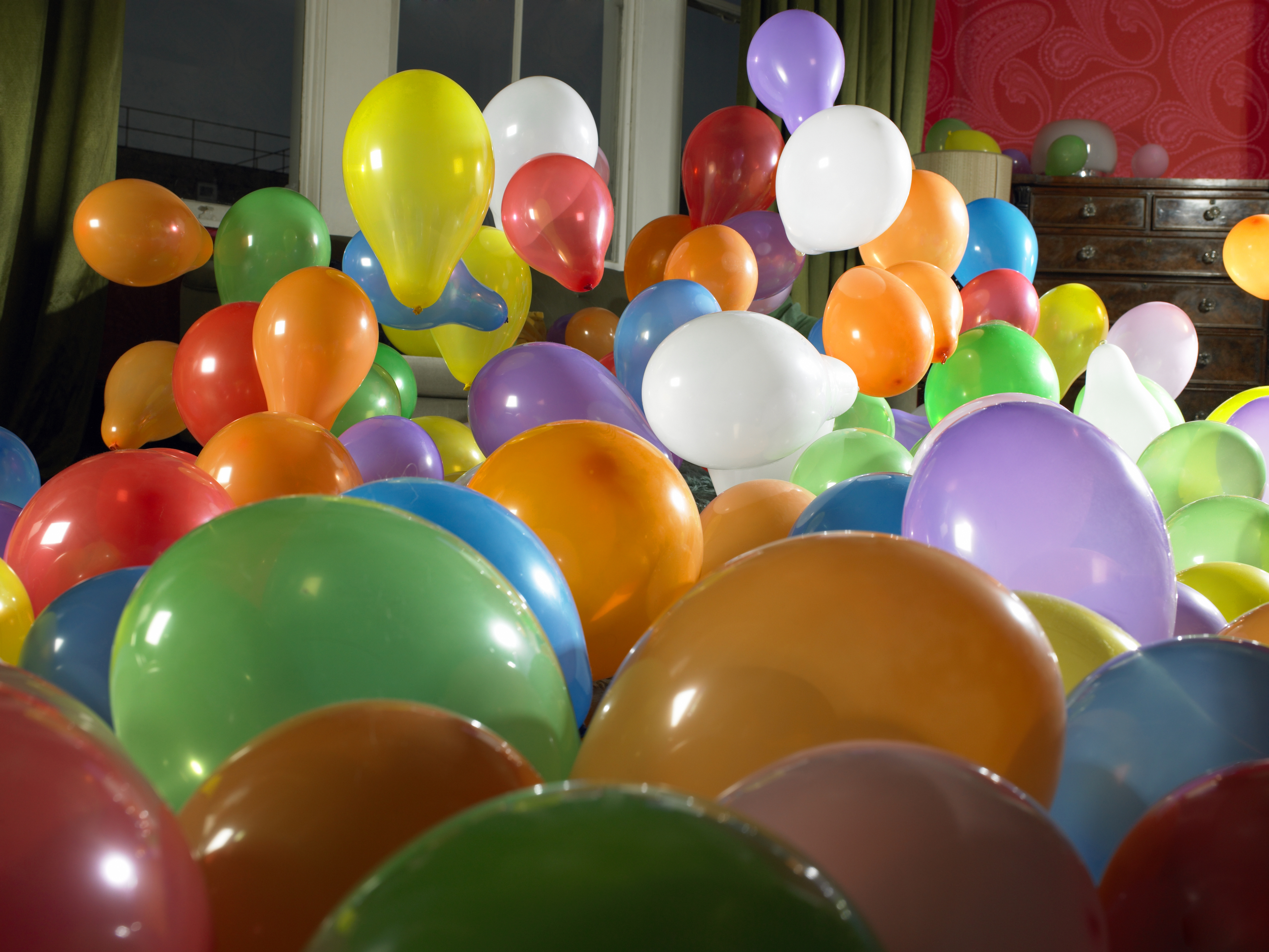 Room filled with multicolored balloons of various sizes