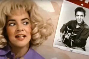 Rizzo wearing a blonde wig and looking at a photo of Elvis.