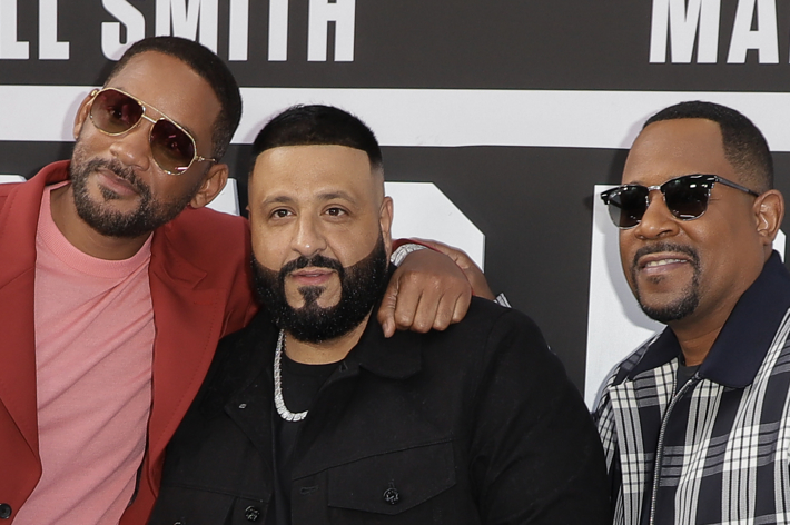 Will Smith in a red suit, DJ Khaled in black, and Martin Lawrence in black sunglasses posing together
