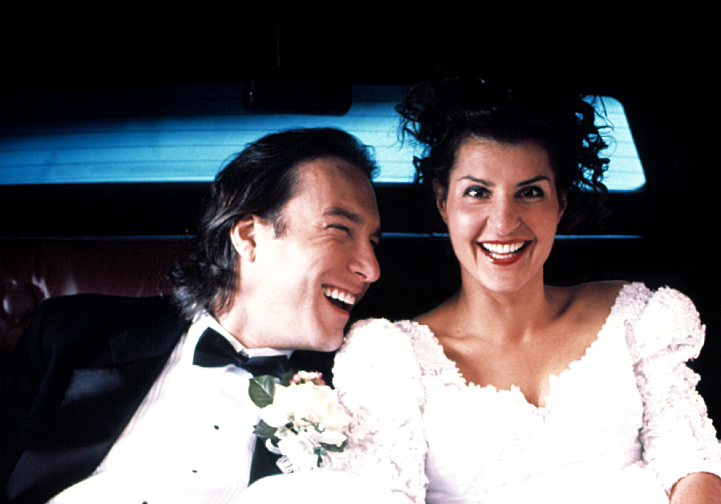 John Corbett and Nia Vardalos from &quot;My Big Fat Greek Wedding&quot; smiling in groom and bride outfits in a car