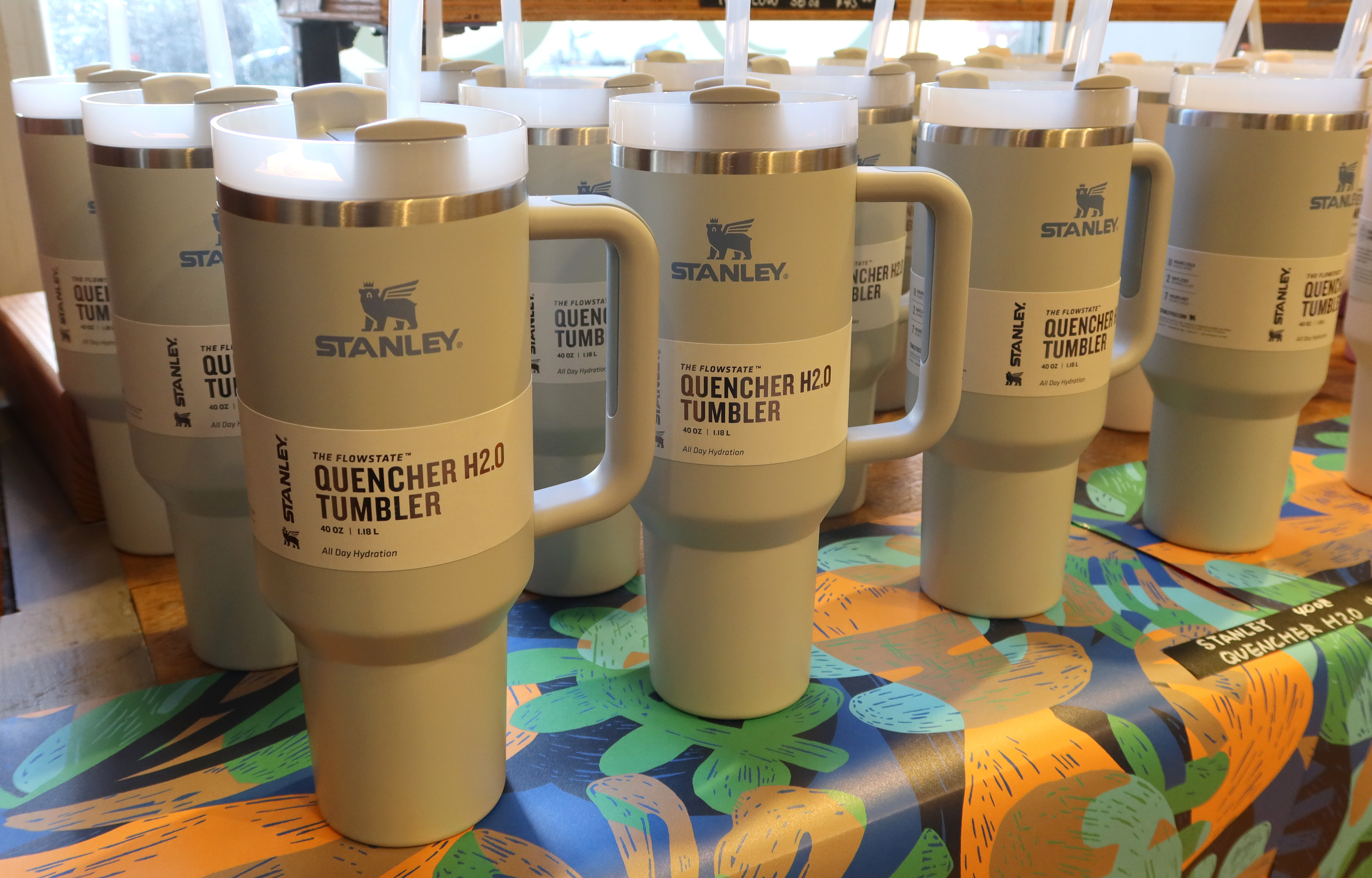 Several Stanley Quencher H2O tumblers displayed on a patterned tablecloth