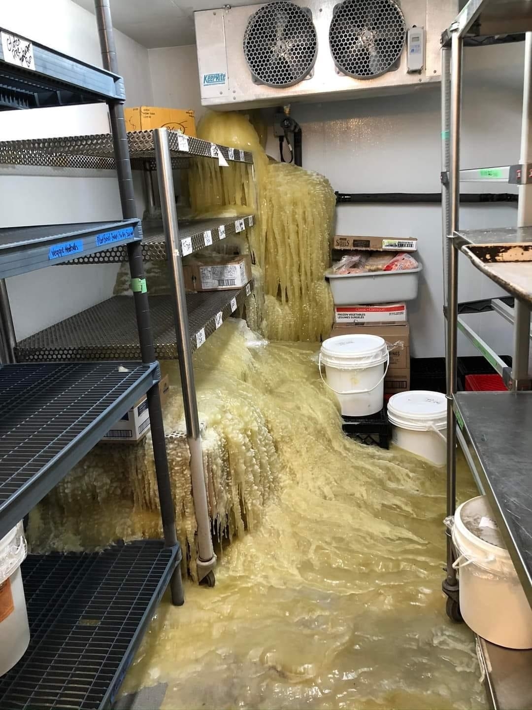 Walk-in cooler with spilled food covering the floor and shelves