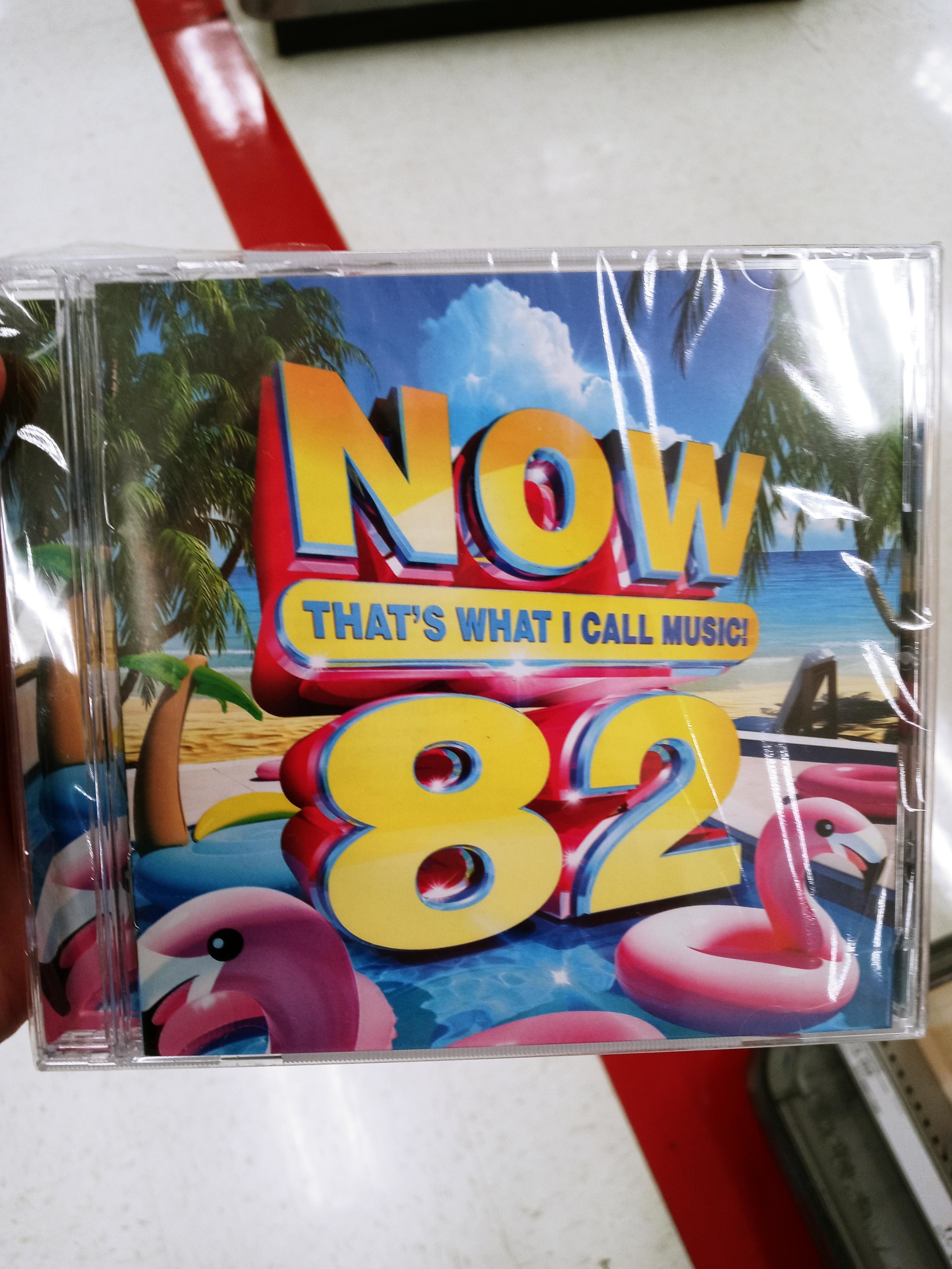 CD cover for &#x27;NOW That’s What I Call Music 82&#x27; with large &#x27;82&#x27; and tropical graphics