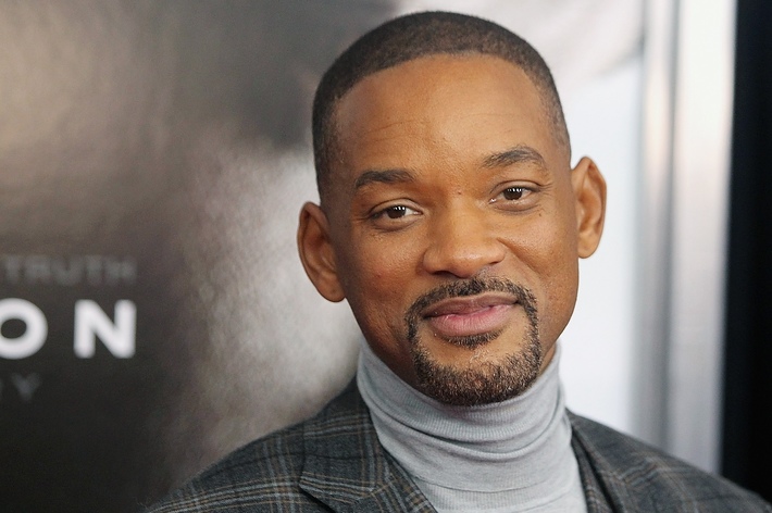 Will Smith wearing a plaid blazer and turtleneck at an event