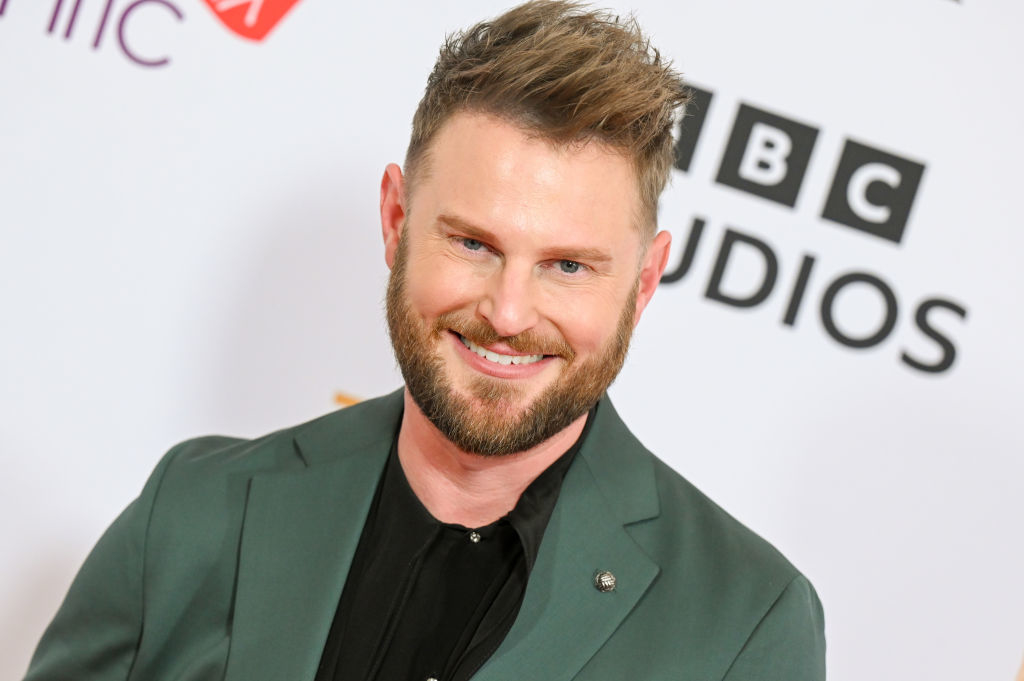 Man in dark suit smiling at a BBC Studios event