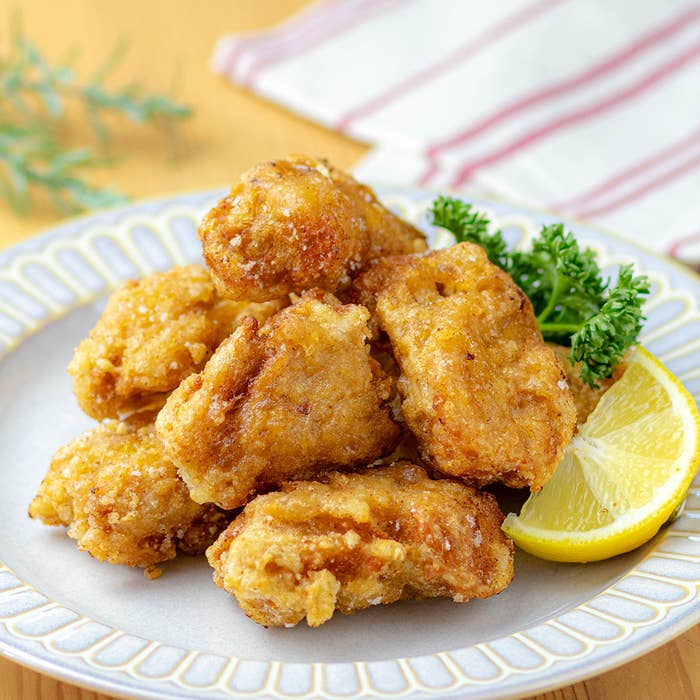 皿に盛られた大豆ミートの唐揚げとレモンスライス、背景にナプキン。