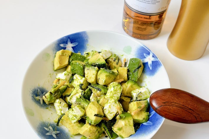 アボカドサラダとウイスキーのボトルがある食事のシーンです。