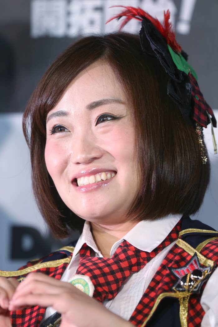 笑顔の女性がチェック柄の衣装を着て、ヘッドピースをつけています。