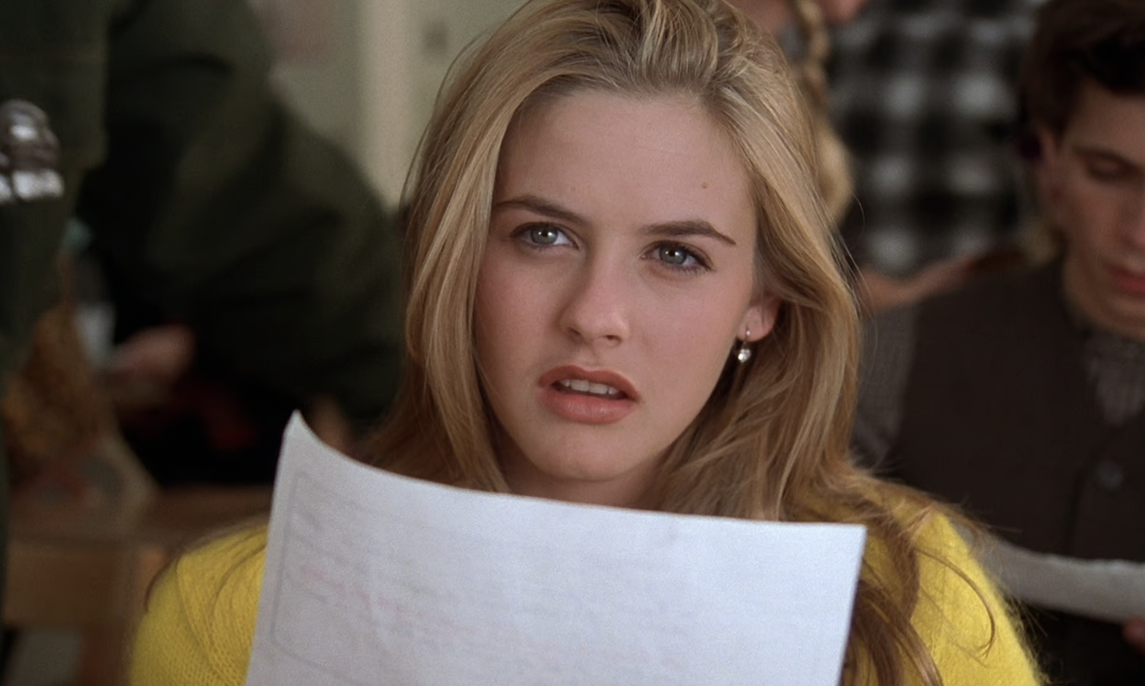 Cher Horowitz from Clueless looks puzzled reading a paper in class