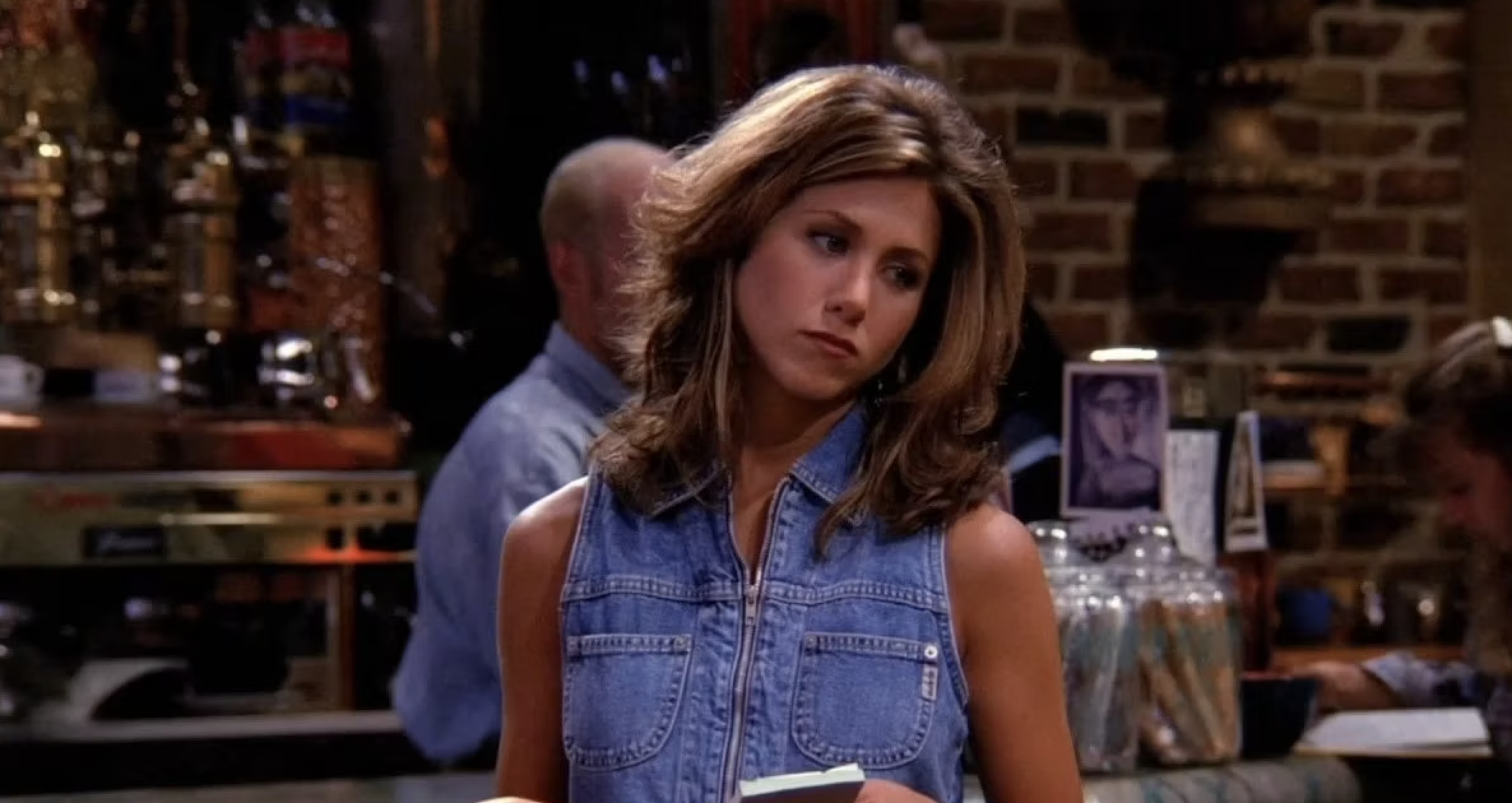 Character Rachel from Friends in Central Perk wearing a denim vest