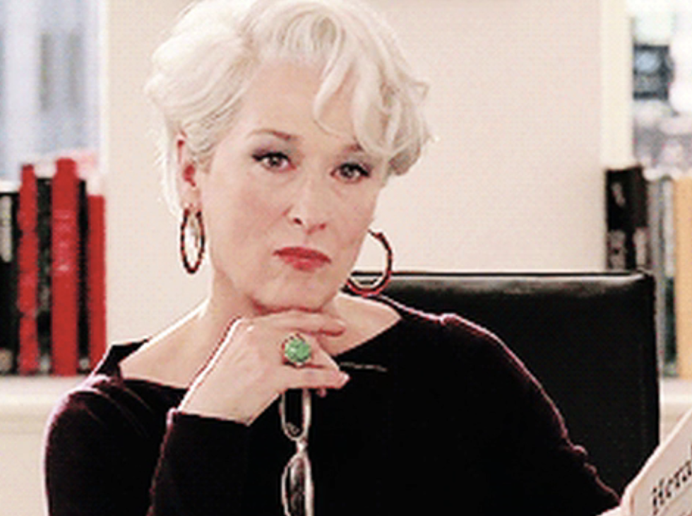Miranda Priestly from 'The Devil Wears Prada' rests chin on hand, showing off large ring, with a contemplative expression